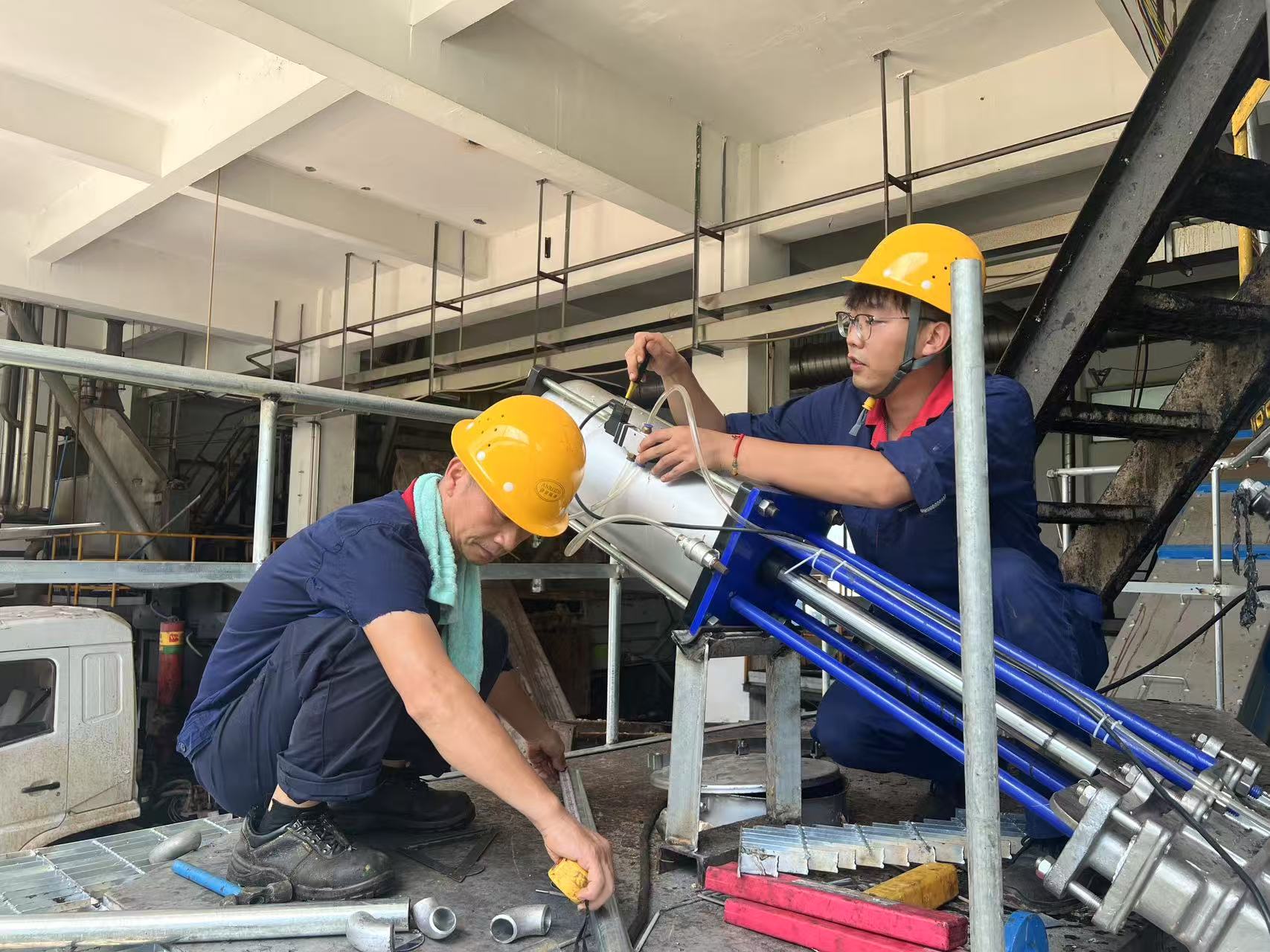 1753239496336.jpg 谌潇毅(右一)和同事在进行气动泵维修.jpg