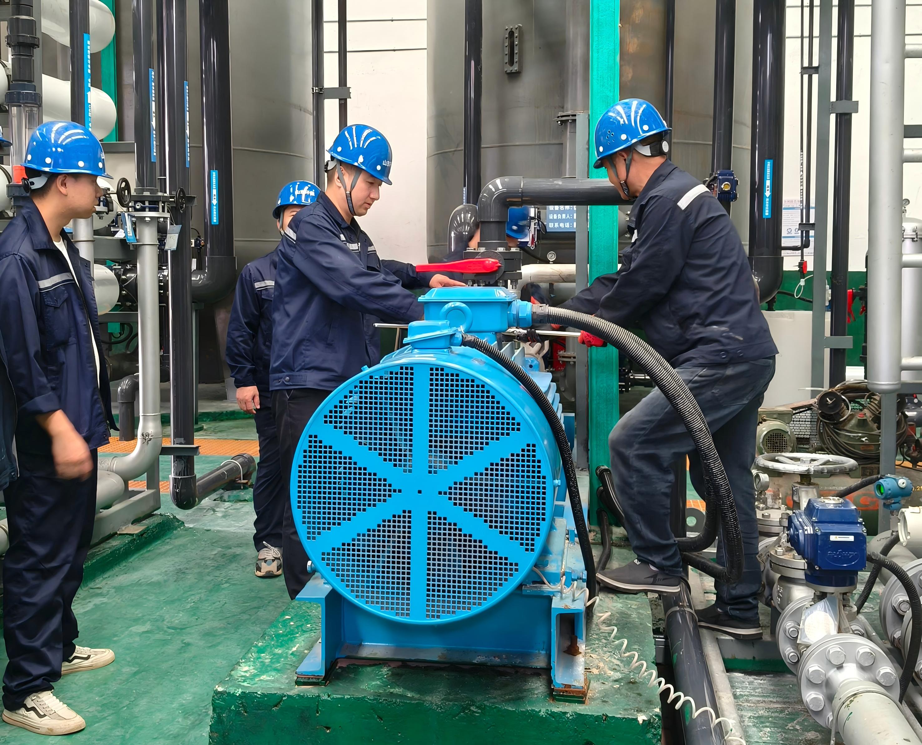图为污水车间主任张学渊（右二）和同事们调整设备.jpg